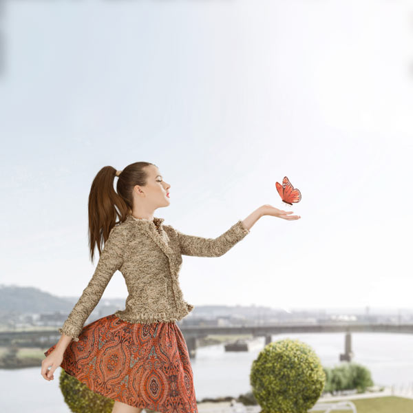 Woman in dress capturing a butterfly. Concept by Gold Dog Communciations for Twelve12 Apartments.